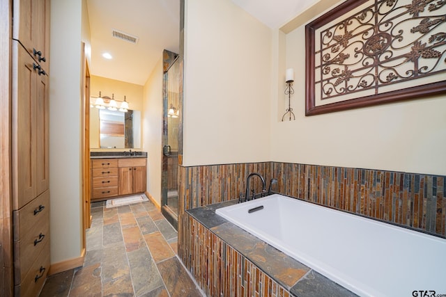 1584 Charlya Dr, Scroggins, TX 75480 - bathroom with stone tile flooring, vanity, a bath, a stall shower, and baseboards