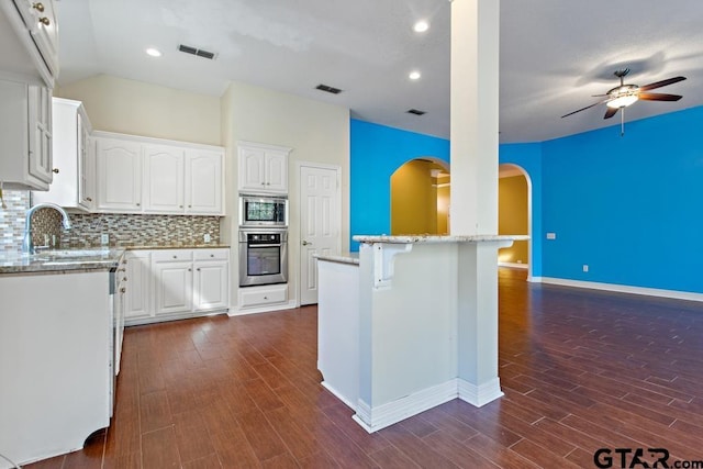 kitchen with dark hardwood / wood-style flooring, stainless steel appliances, ceiling fan, sink, and white cabinets