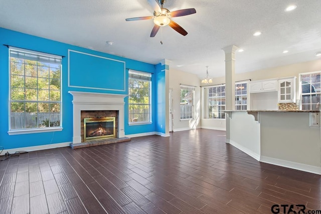 unfurnished living room featuring dark hardwood / wood-style flooring, a brick fireplace, and plenty of natural light