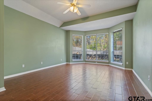 spare room featuring ceiling fan, dark wood-type flooring, and a textured ceiling