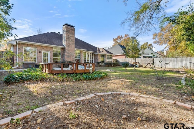 rear view of property with a deck and a yard