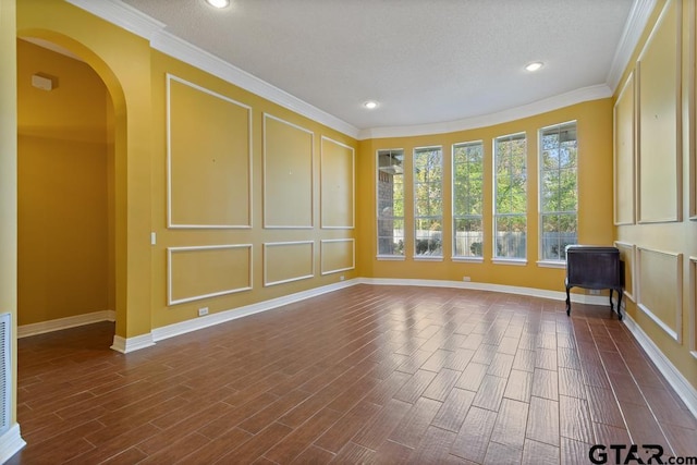 spare room with a textured ceiling, dark hardwood / wood-style flooring, and crown molding