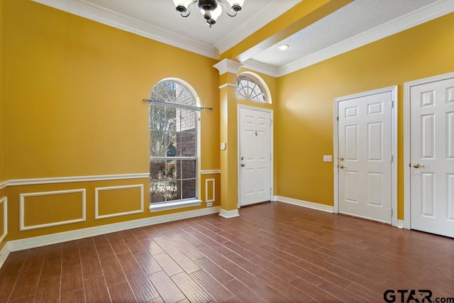 foyer featuring ornamental molding, ornate columns, and dark wood-type flooring