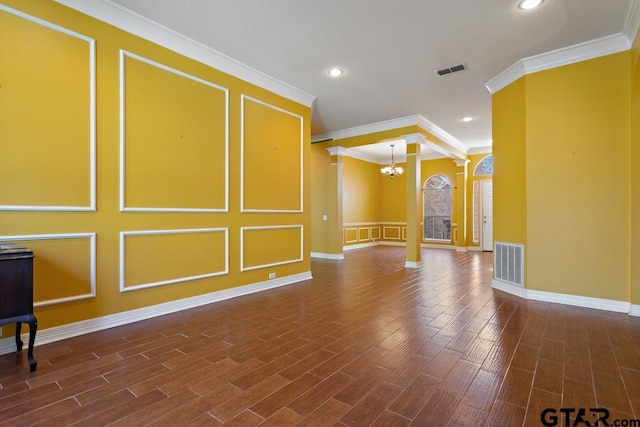 empty room featuring a notable chandelier, crown molding, and dark wood-type flooring