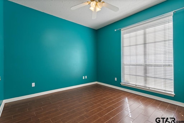 spare room featuring dark hardwood / wood-style floors, a wealth of natural light, and ceiling fan