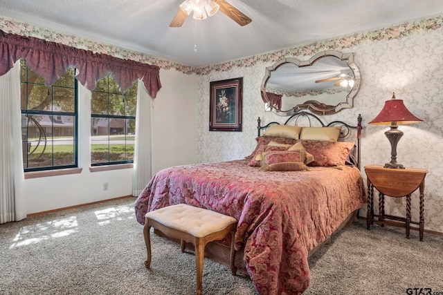 carpeted bedroom with ceiling fan and a textured ceiling