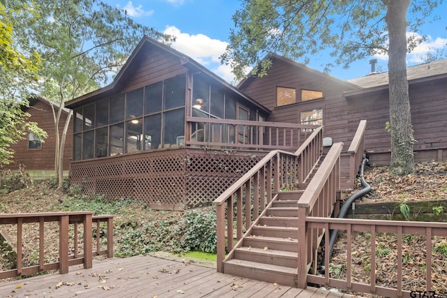 rear view of house featuring a sunroom and a wooden deck