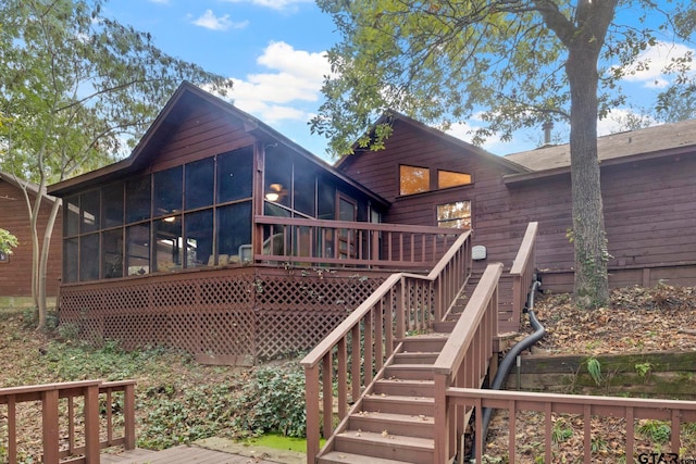 back of property featuring a wooden deck and a sunroom