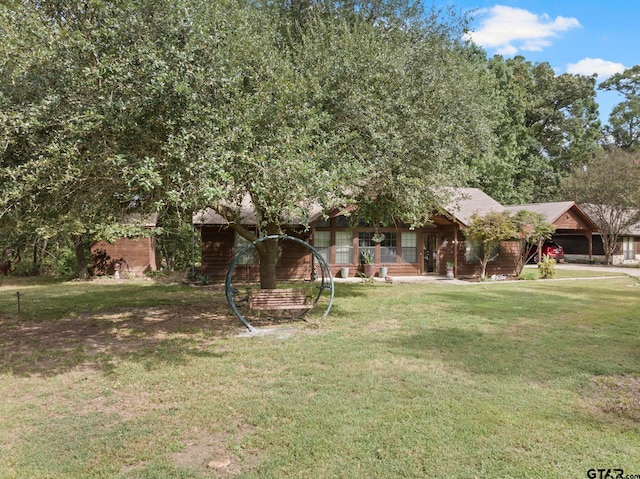 view of property hidden behind natural elements featuring a front lawn