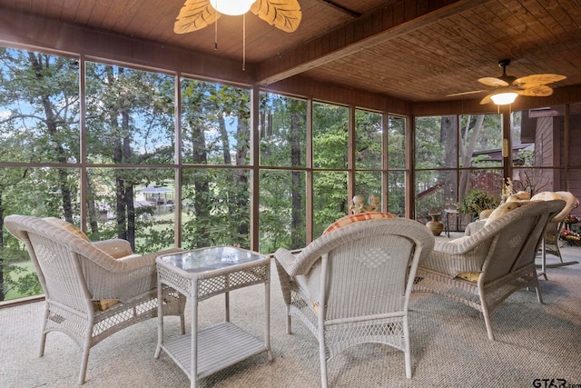 sunroom / solarium featuring beam ceiling, wood ceiling, ceiling fan, and plenty of natural light