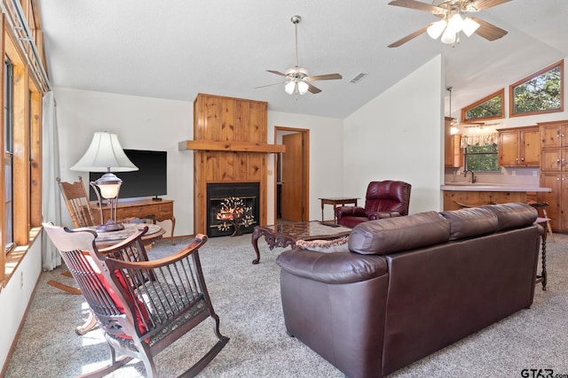 living room featuring light colored carpet, vaulted ceiling, sink, ceiling fan, and a fireplace