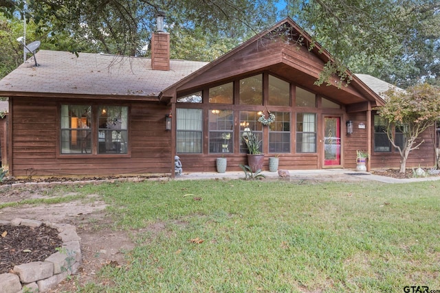 rear view of property with a lawn