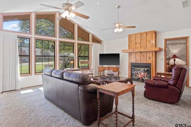 carpeted living room with ceiling fan, a large fireplace, and plenty of natural light