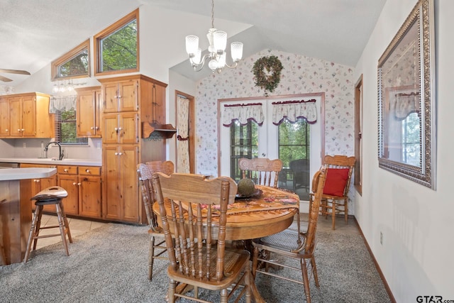 dining room with light colored carpet, ceiling fan with notable chandelier, sink, and lofted ceiling