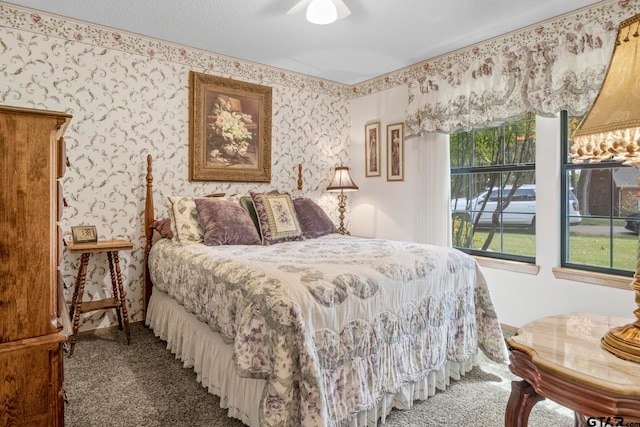 carpeted bedroom featuring a textured ceiling and ceiling fan