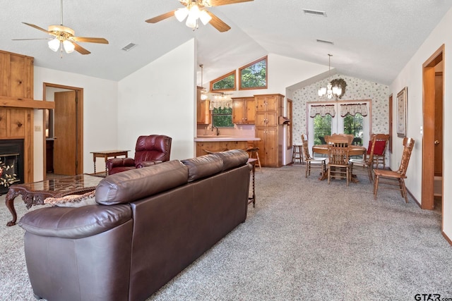 living room featuring sink, ceiling fan with notable chandelier, light carpet, and vaulted ceiling