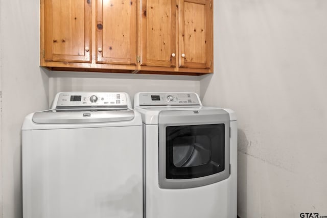 laundry room featuring cabinets and washer and dryer