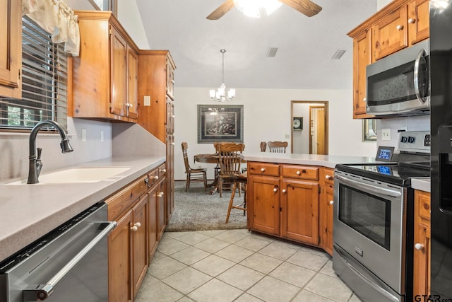 kitchen featuring light tile patterned flooring, appliances with stainless steel finishes, hanging light fixtures, sink, and ceiling fan with notable chandelier