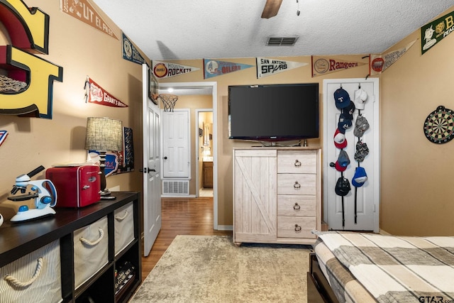 10769 Indigo Ln, Flint, TX 75762 - bedroom featuring a textured ceiling, wood finished floors, and ceiling fan