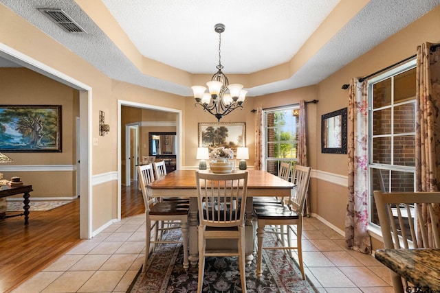10769 Indigo Ln, Flint, TX 75762 - dining room with a chandelier, light tile patterned floors, a textured ceiling, and a tray ceiling