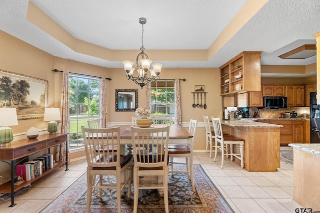 10769 Indigo Ln, Flint, TX 75762 - dining space featuring light tile patterned floors, a textured ceiling, a chandelier, and a tray ceiling