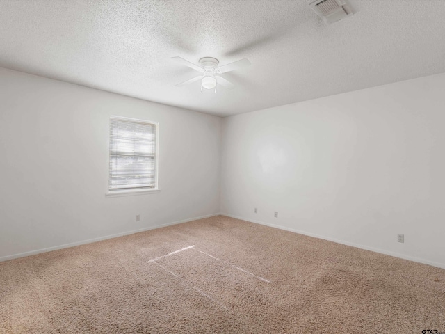 empty room with visible vents, baseboards, ceiling fan, carpet, and a textured ceiling