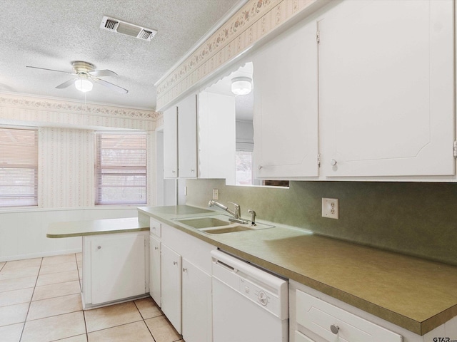 kitchen with white dishwasher, a sink, visible vents, and wallpapered walls