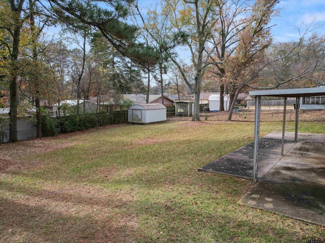 view of yard featuring a shed, fence, and an outbuilding