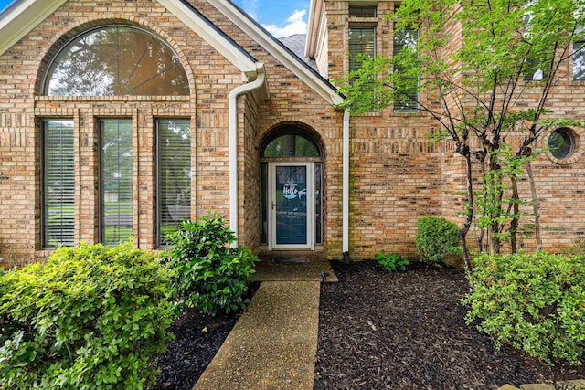 property entrance featuring brick siding