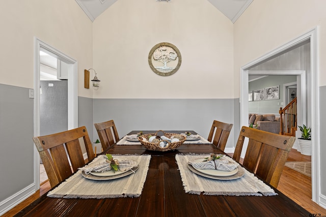dining space featuring stairs, baseboards, dark wood finished floors, and high vaulted ceiling