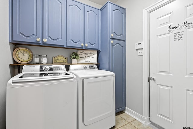 clothes washing area with cabinet space, light tile patterned floors, baseboards, and washer and clothes dryer