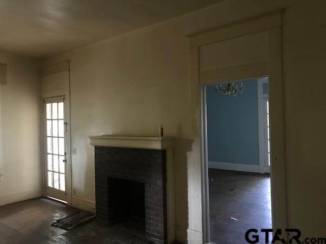 unfurnished living room with dark wood-type flooring and a fireplace