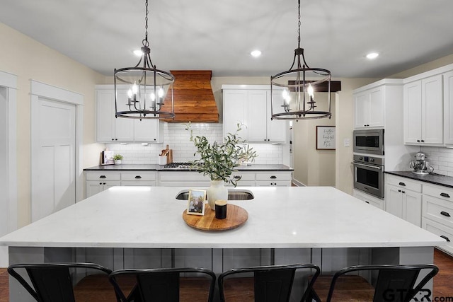 429 Coventry, Bullard, TX 75757 - kitchen featuring stainless steel appliances, tasteful backsplash, a chandelier, white cabinetry, and a center island with sink