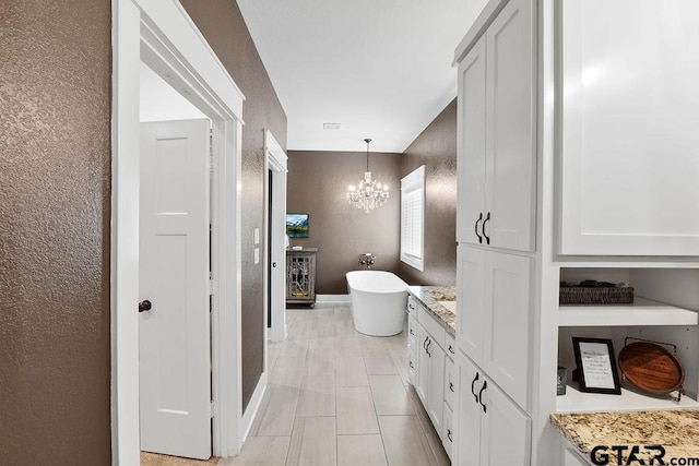 429 Coventry, Bullard, TX 75757 - bathroom featuring a soaking tub, a chandelier, baseboards, vanity, and a textured wall
