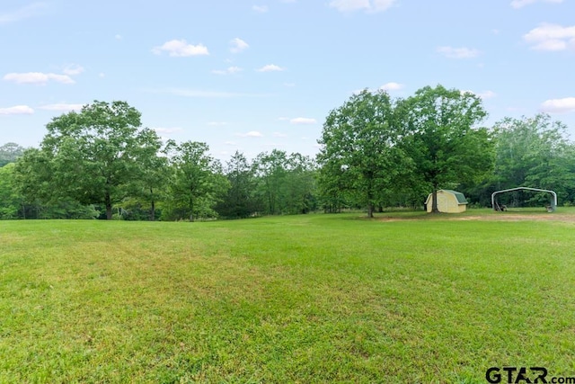 841 Pops Landing Rd, Ore City, TX 75683 - view of green lawn featuring a carport and a storage unit