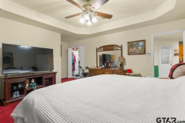 841 Pops Landing Rd, Ore City, TX 75683 - bedroom featuring a walk in closet, a tray ceiling, ceiling fan, and a closet