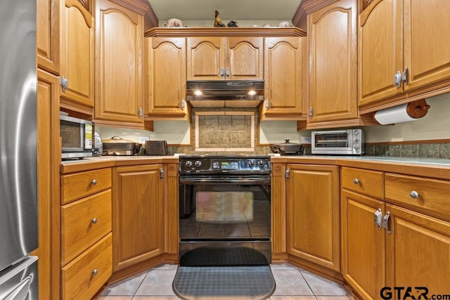 841 Pops Landing Rd, Ore City, TX 75683 - kitchen with stainless steel appliances, under cabinet range hood, light tile patterned floors, and tasteful backsplash