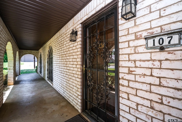 view of exterior entry featuring brick siding