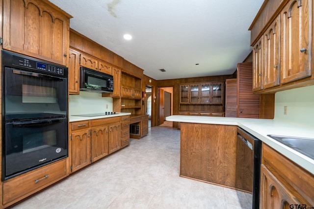 kitchen with black appliances, light countertops, and brown cabinetry