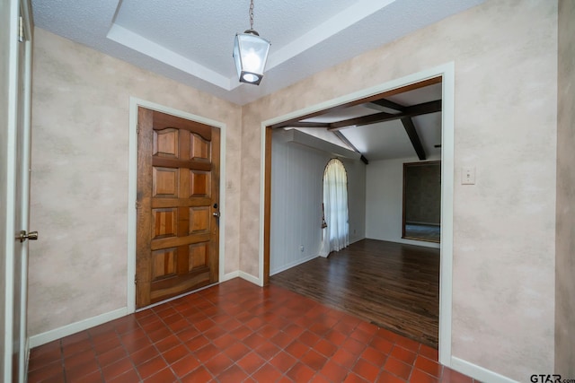 tiled foyer with a textured ceiling, arched walkways, vaulted ceiling with beams, and baseboards