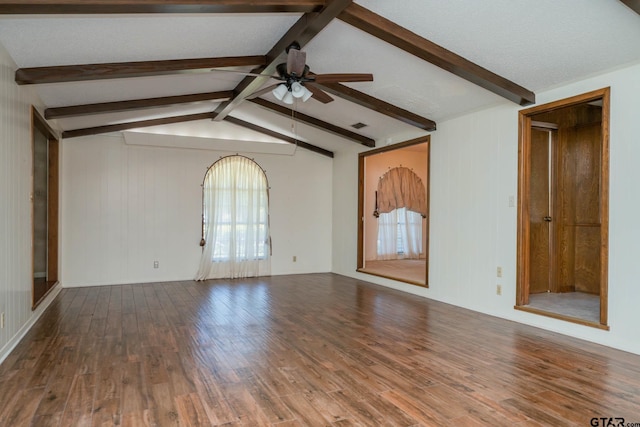spare room featuring wood finished floors, lofted ceiling with beams, a ceiling fan, and visible vents