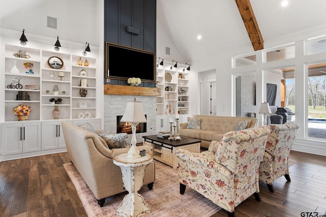 living room featuring beamed ceiling, hardwood / wood-style floors, high vaulted ceiling, and a stone fireplace