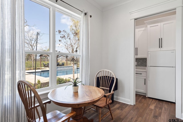 dining space with crown molding and dark wood-type flooring