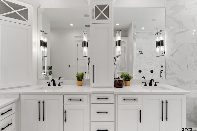 bathroom with a tile shower and vanity