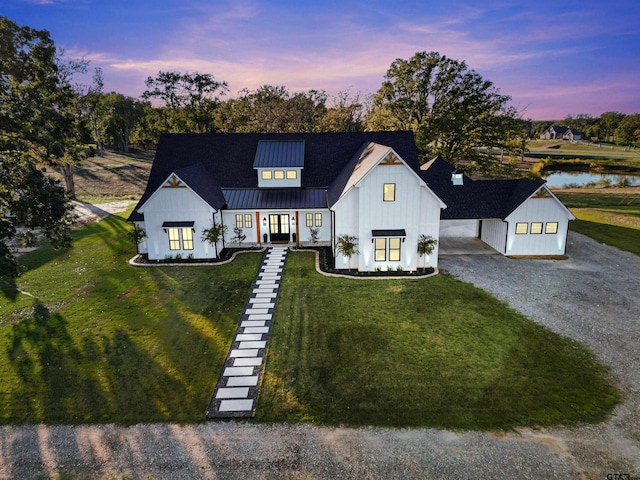 modern inspired farmhouse featuring a water view and a yard