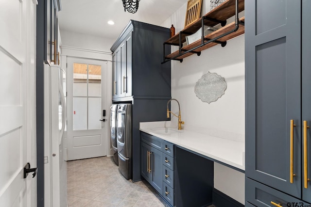 laundry room with cabinets, sink, and washing machine and clothes dryer