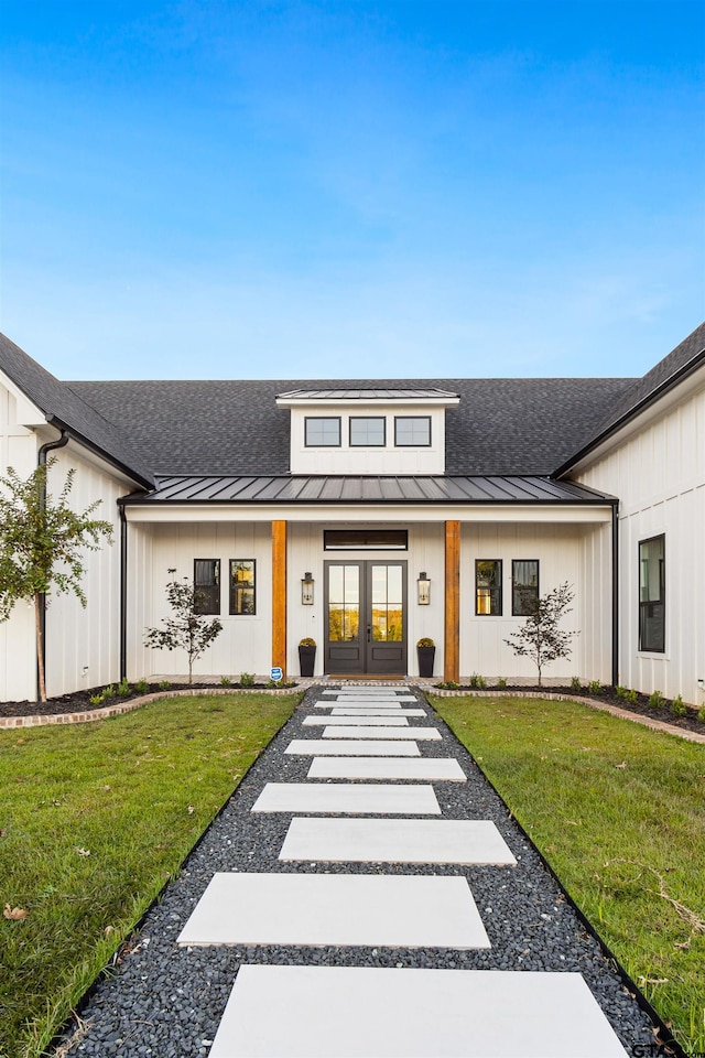 view of front of home with french doors and a front lawn