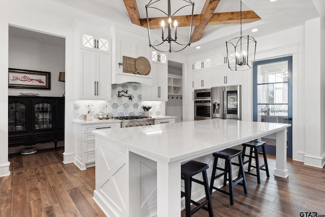 kitchen featuring white cabinets, a spacious island, pendant lighting, and built in appliances