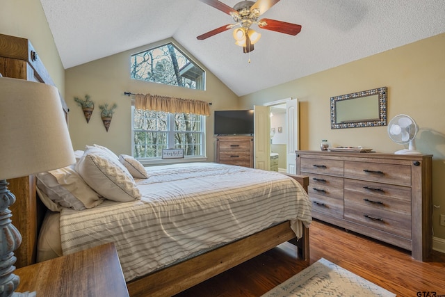 bedroom featuring ensuite bathroom, hardwood / wood-style floors, ceiling fan, lofted ceiling, and a textured ceiling