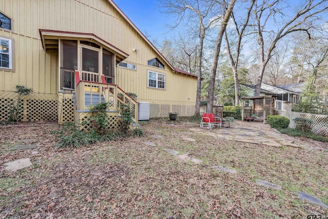 rear view of property with a sunroom and a patio